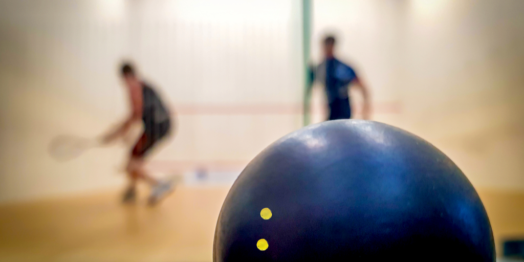 Giocatori di squash con pallina due punti gialli